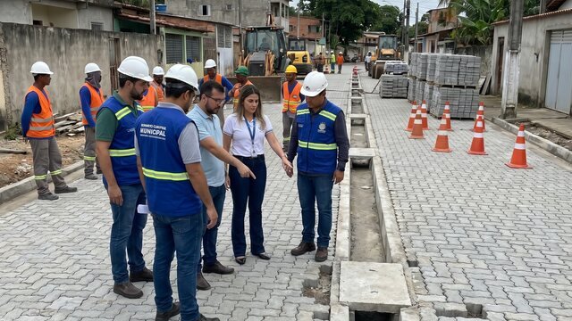 Equipe técnica vistoriando obra pública em rua pavimentada